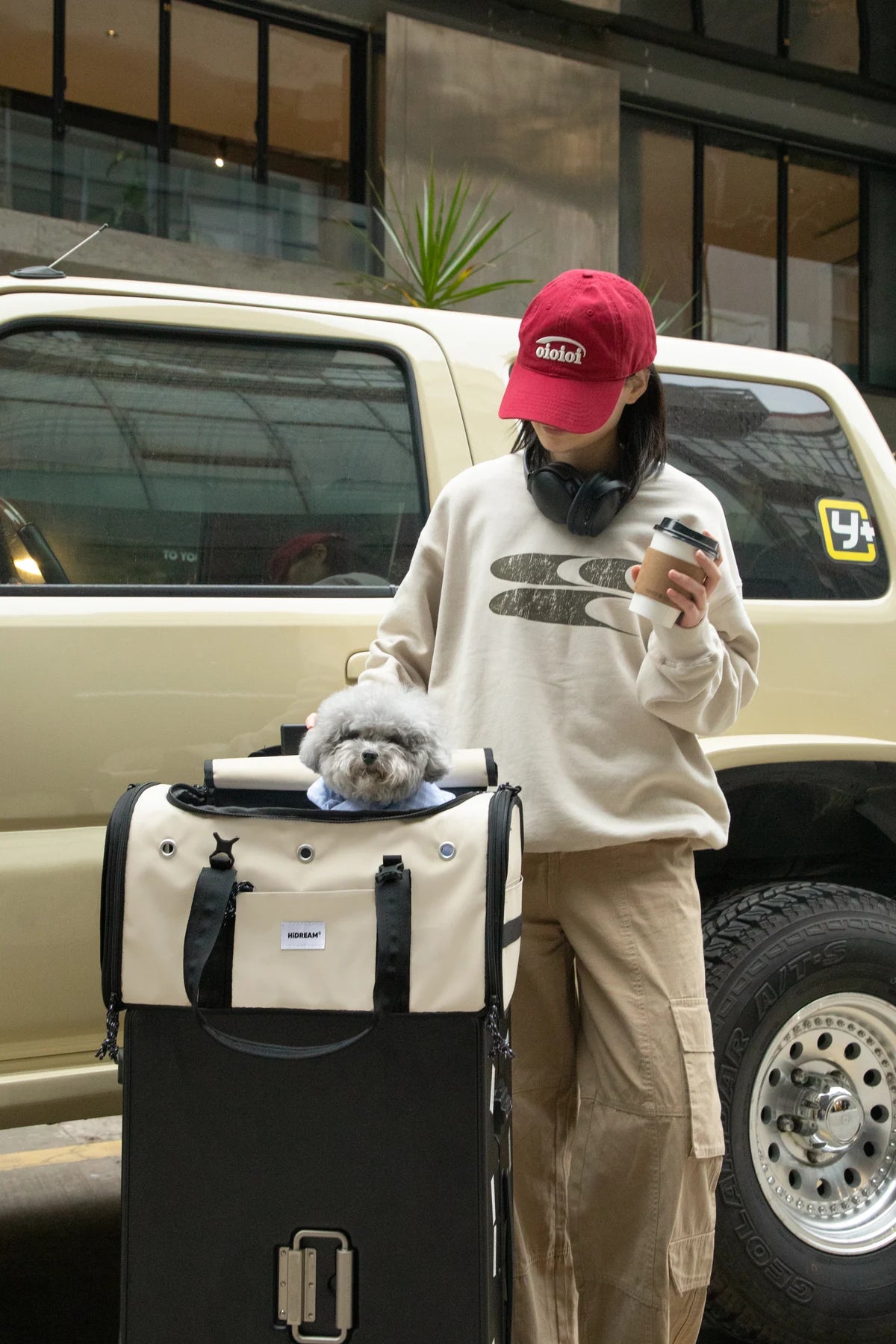 Owner beside the Dune Brown carrier resting on separate luggage outdoors