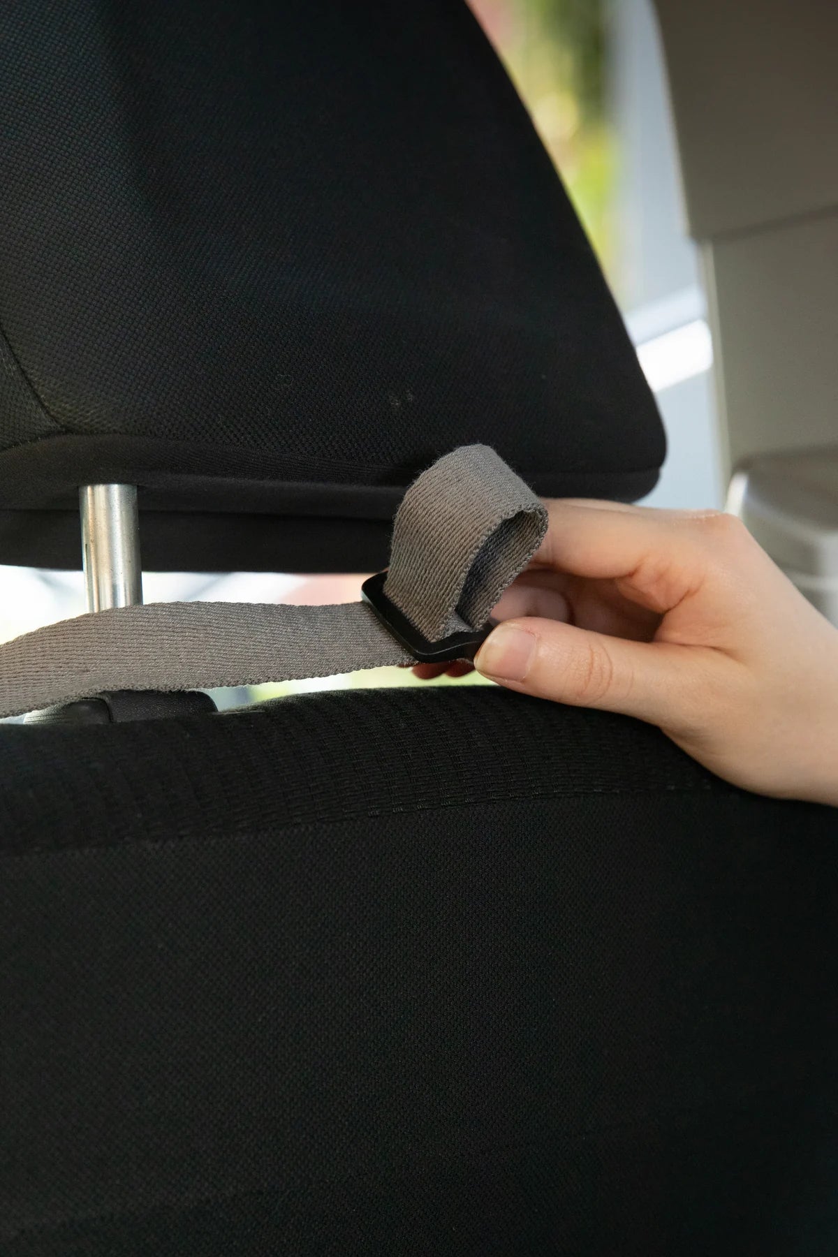 Cover strap fastened around a seat headrest