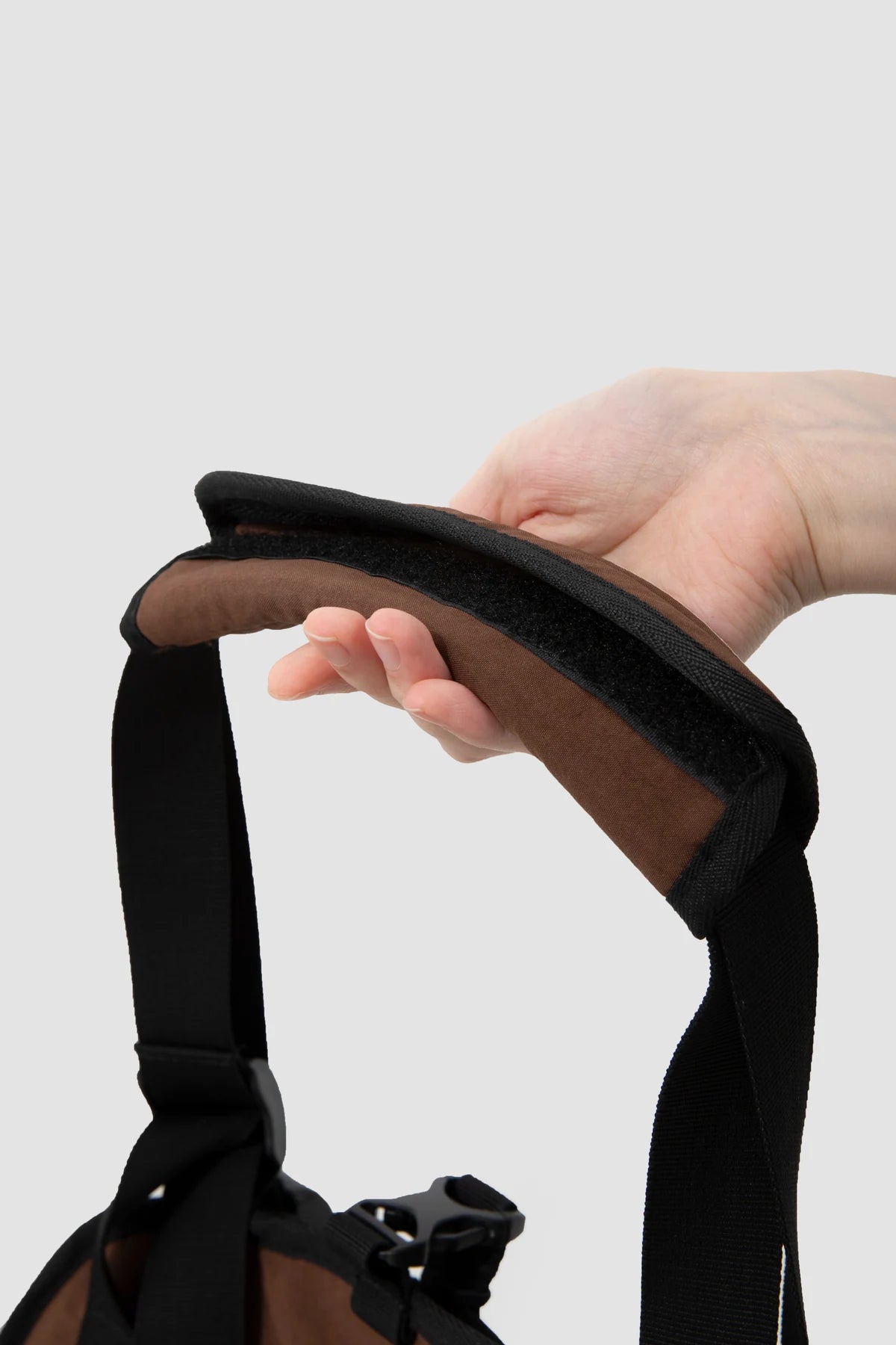 Close view of the brown padded shoulder wrap and strap adjustment on the Baguette carrier