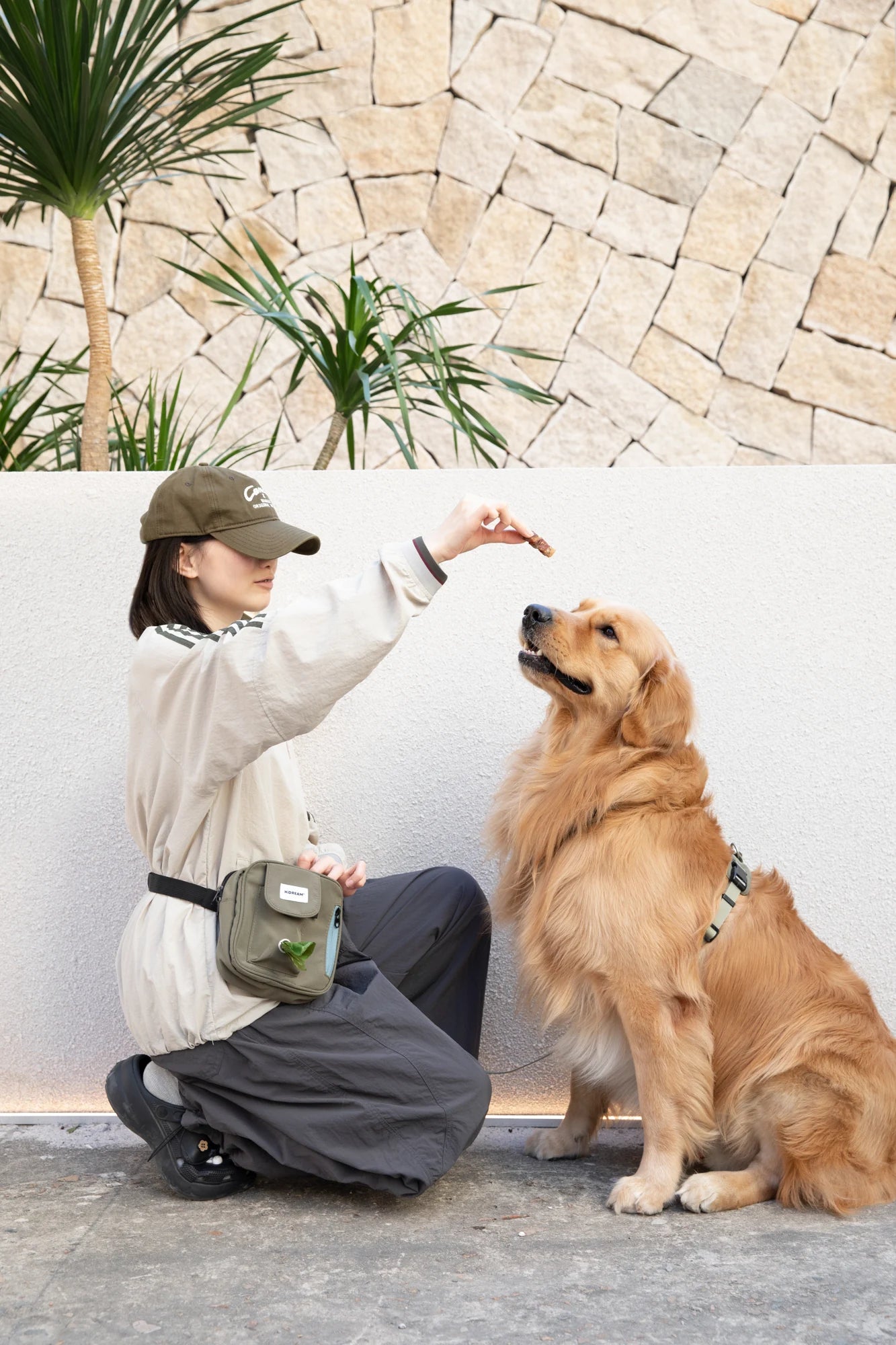 Handler rewarding a dog with the Deep Moss Green Toast pouch nearby