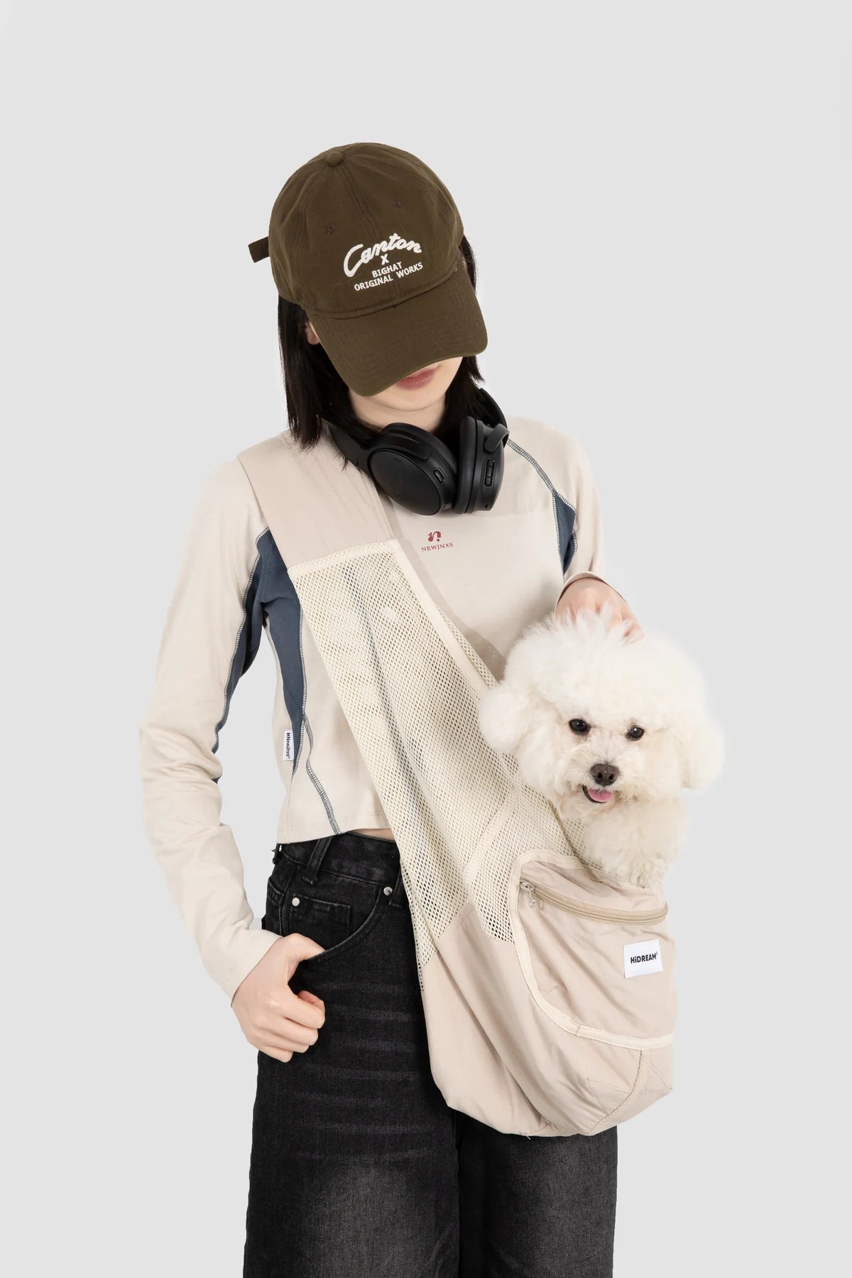 Dog supported in the Milk Tea Brown sling worn by its owner