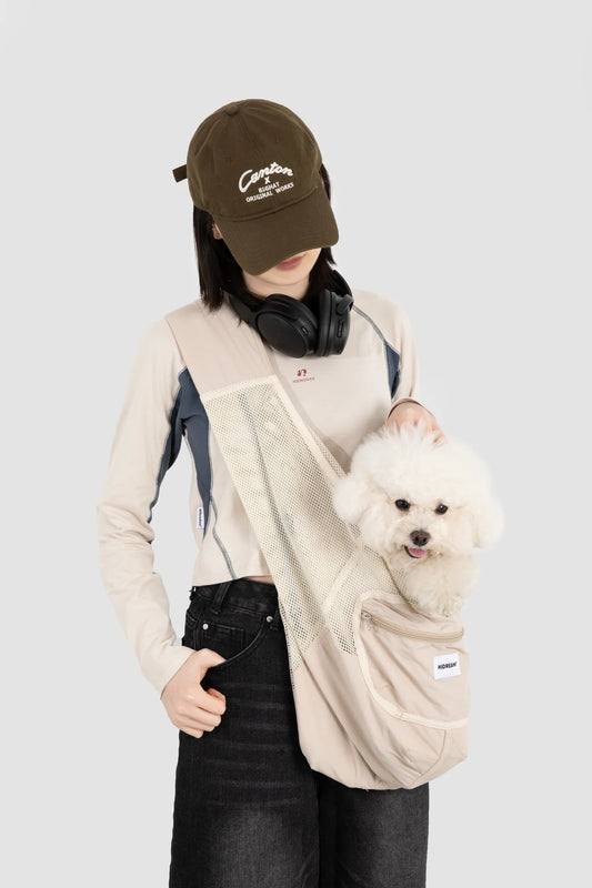 Dog supported in the Milk Tea Brown sling worn by its owner
