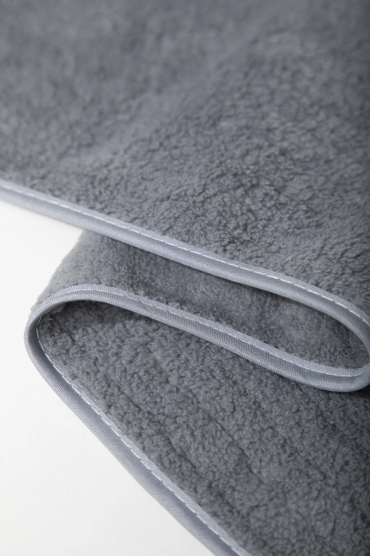 Close view of the gray towel texture and bound edge