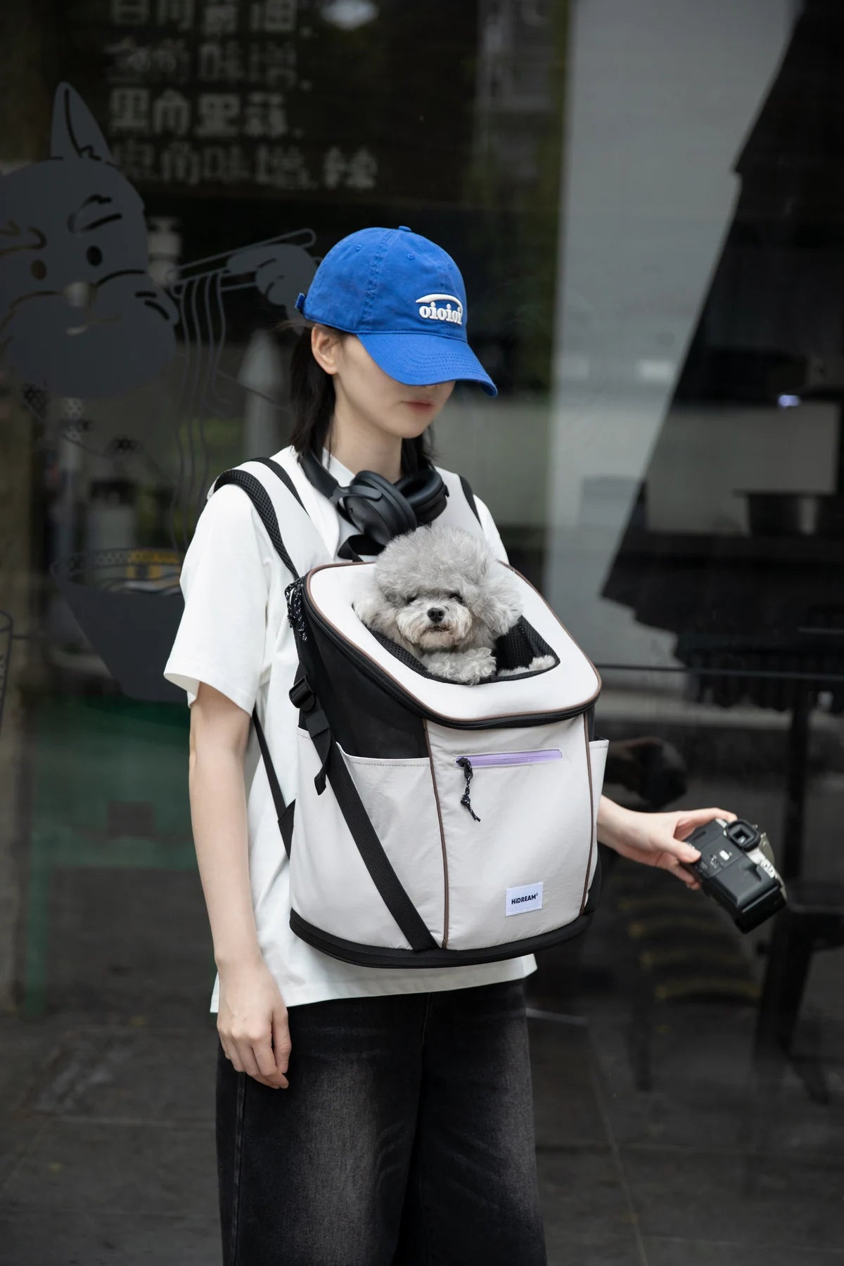 Owner carrying a cat in the Gray carrier outside a cafe