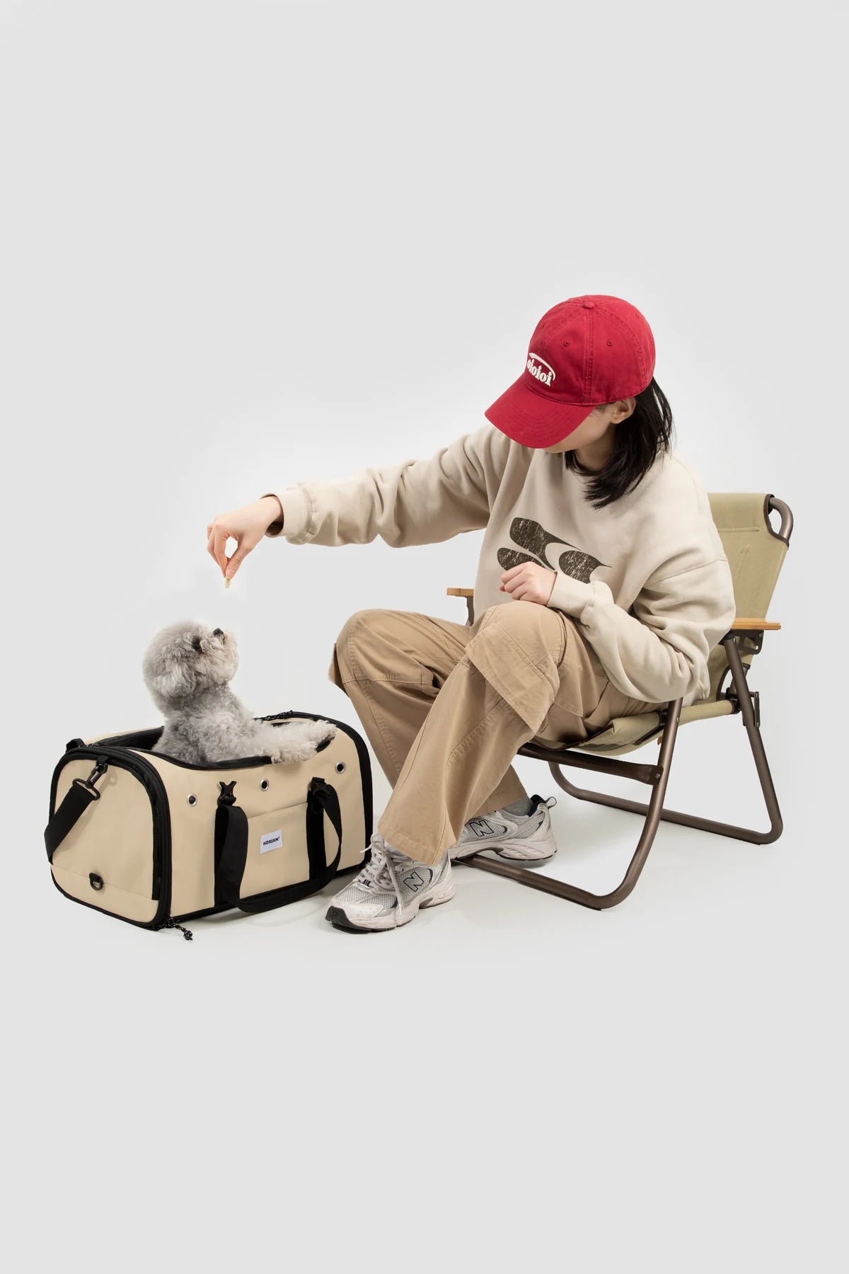 Owner sitting beside a cat and the opened Dune Brown carrier