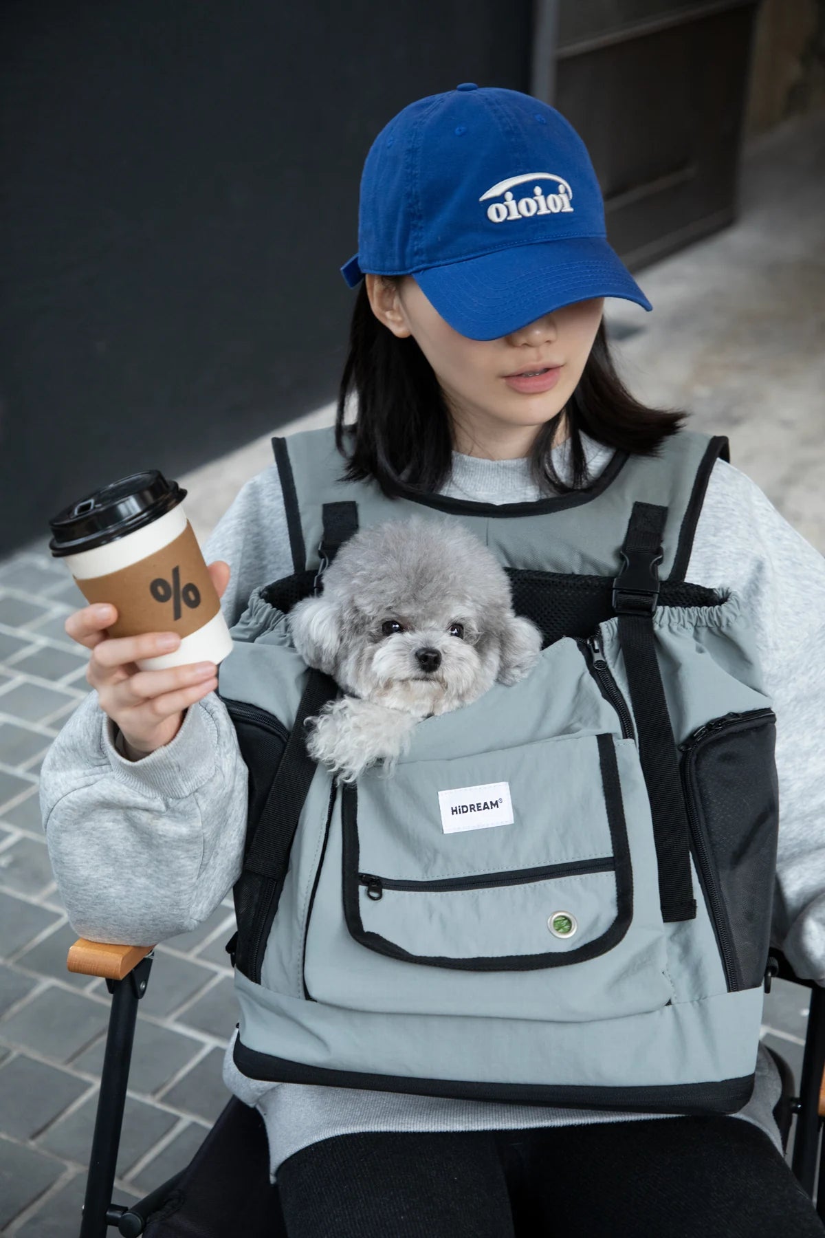 Owner with a pet in the Volcanic Gray carrier outside a cafe