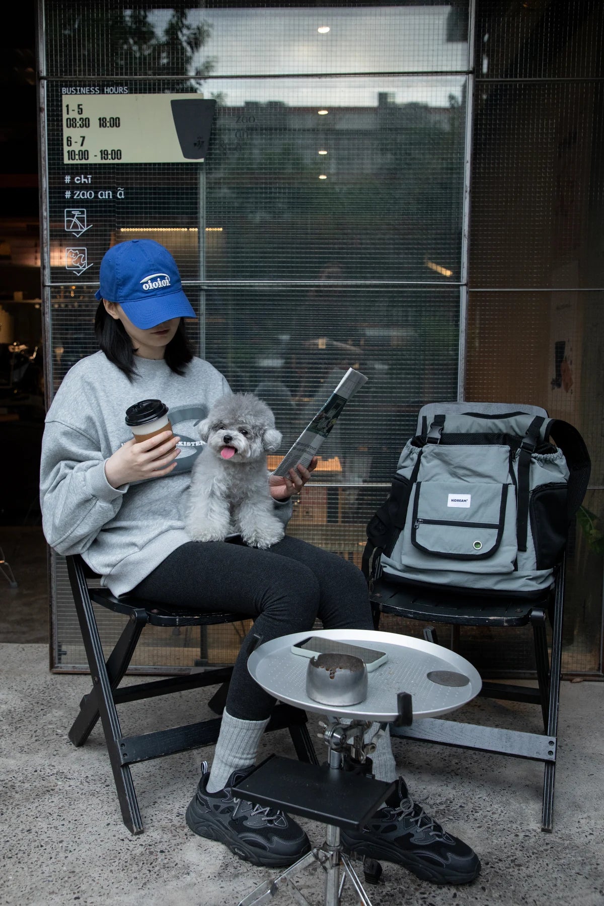 Owner sitting beside the Gray carrier at a cafe