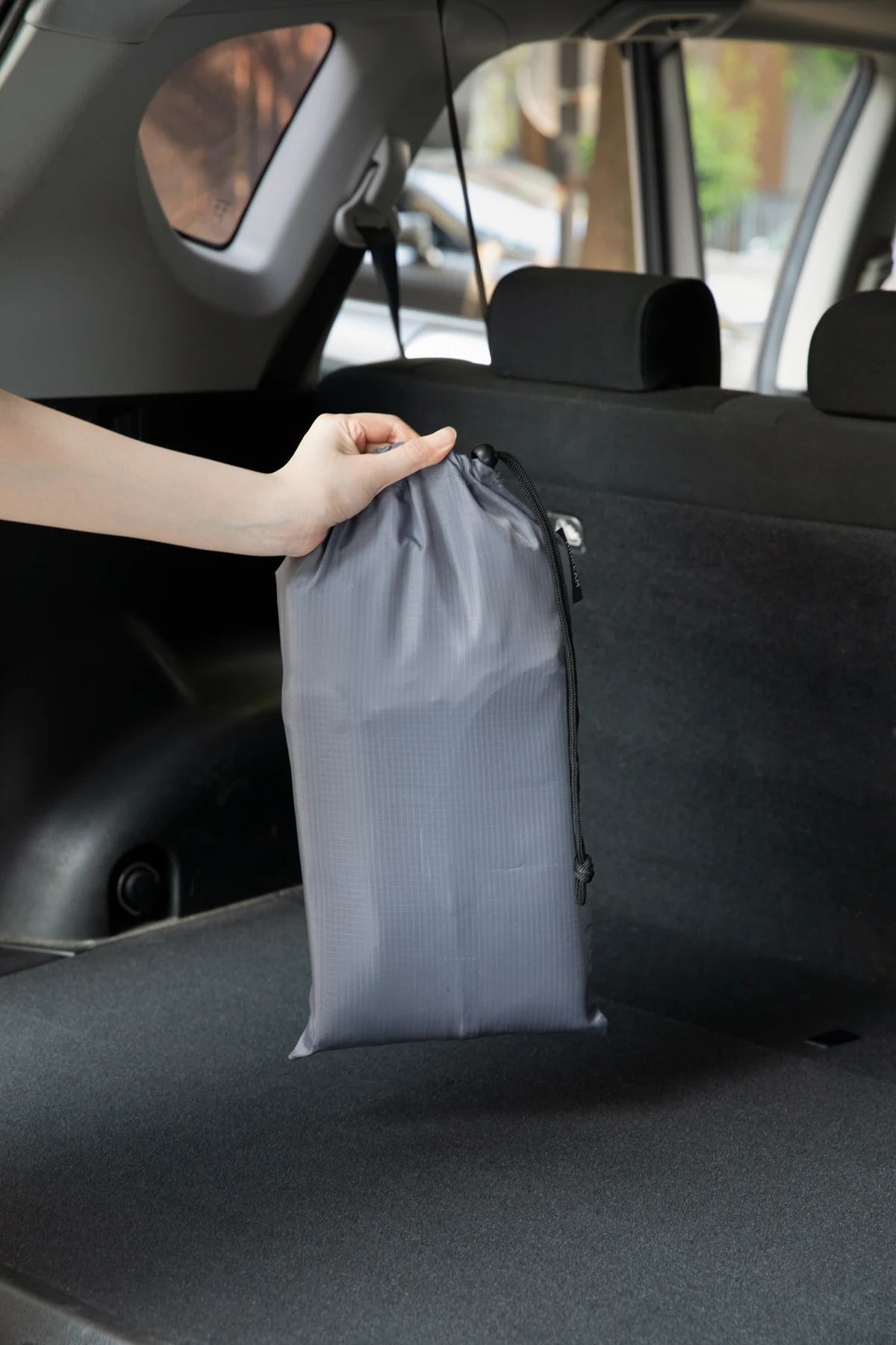 Seat cover stored in its bag behind a seat