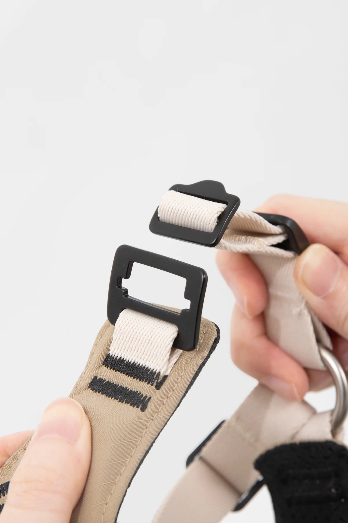 Opening buckle on the sport harness shown by hand
