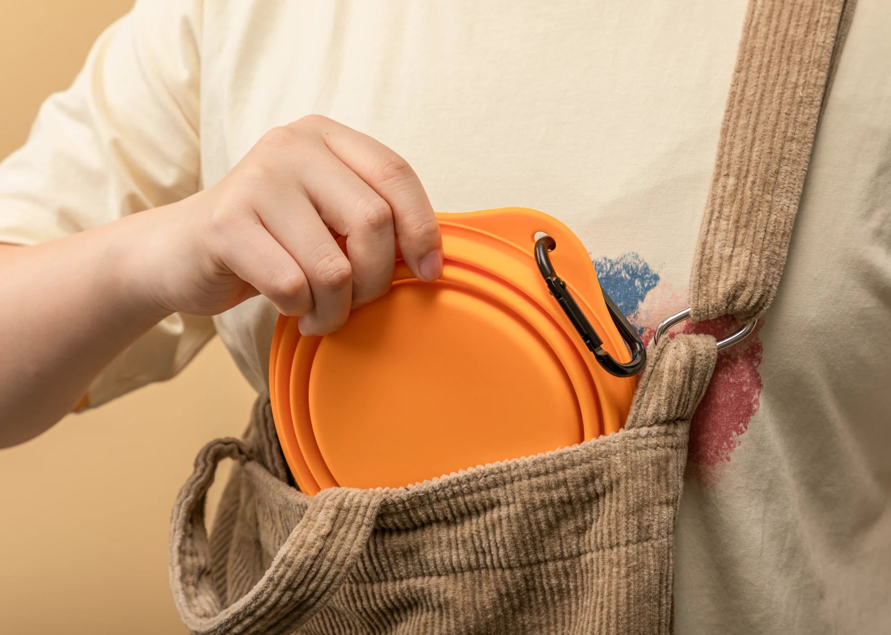 Folded bowl being slipped into a bag pocket
